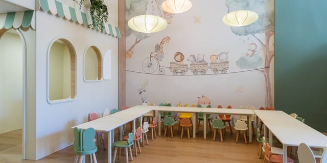 Mural sa vozićem i životinjama iznad dečjih stolova